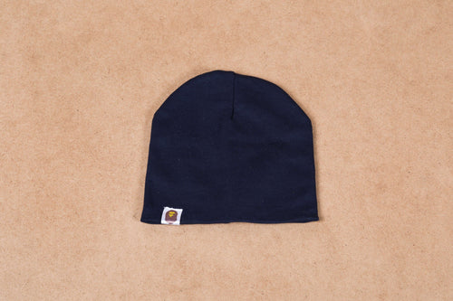Navy blue beanie hat with small tag detail on beige background