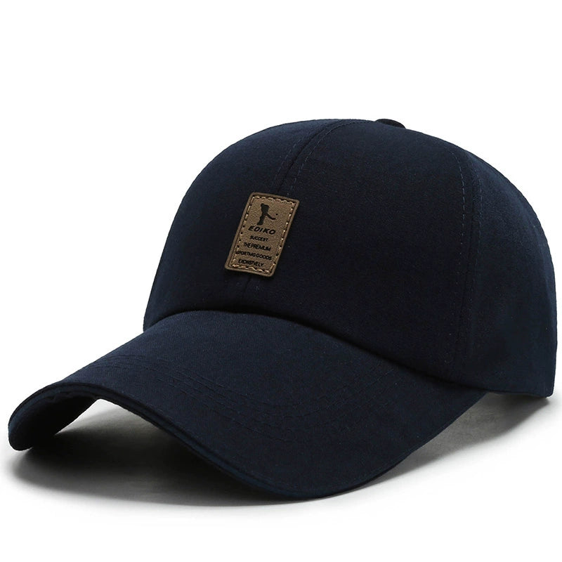 Black baseball cap with curved brim and brown patch logo on the front