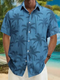 Blue short-sleeve button-up shirt with palm tree print, worn at a tropical beach