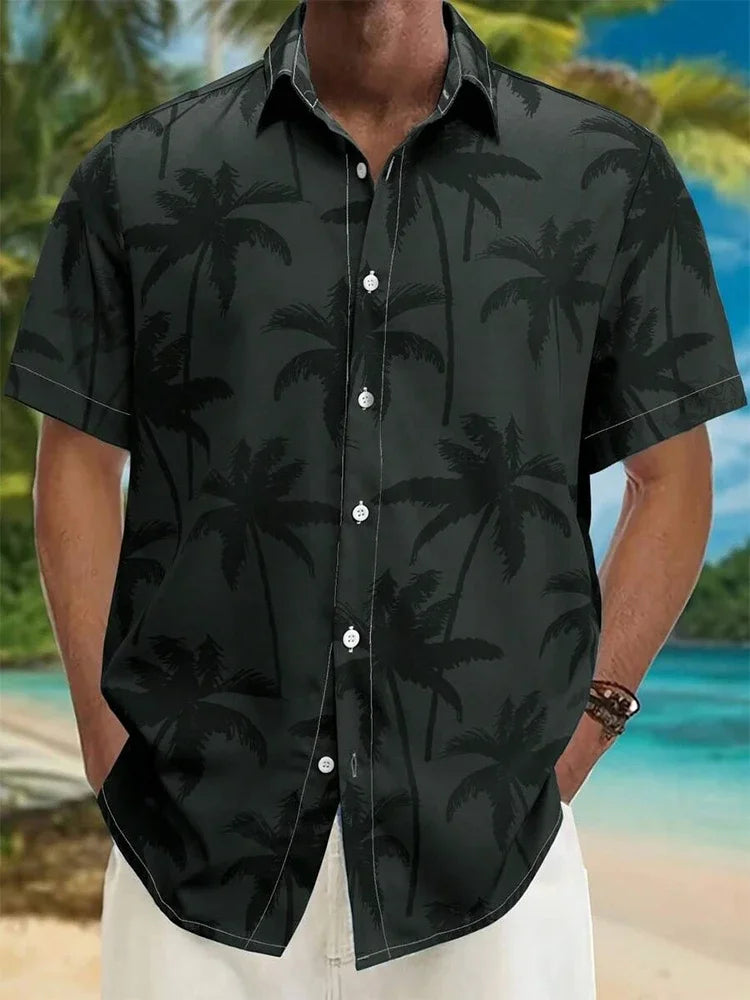 Men’s short sleeve black button-up shirt with palm tree print, worn on a tropical beach.