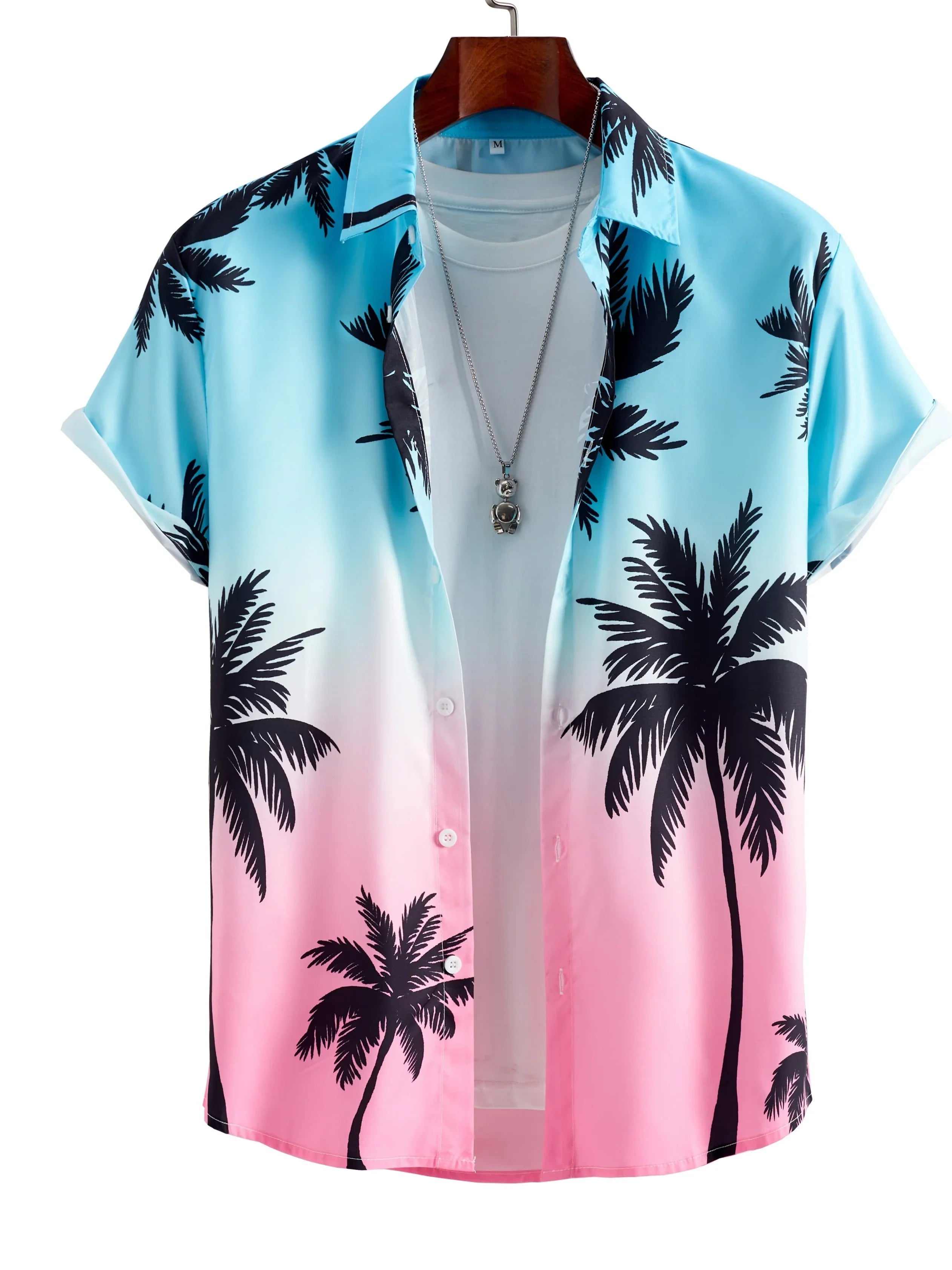 Tropical palm tree print shirt in blue to pink gradient, displayed on a hanger with necklace.