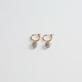 Gold hoop earrings with oval dalmatian jasper stone charms on white background