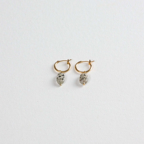 Gold hoop earrings with oval dalmatian jasper stone charms on white background